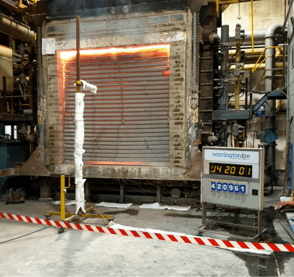 Close up of garage door showcasing a fireproof shutter, with flames seen in the background